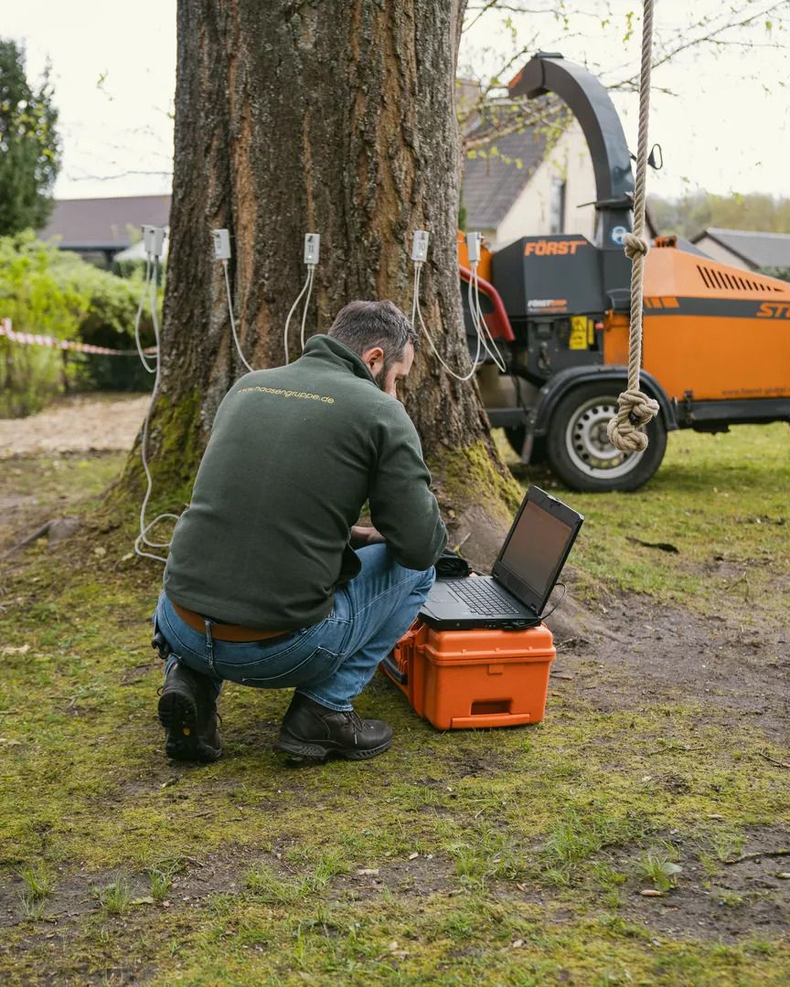 Ein Mitarbeiter arbeitet im Freien an einem Laptop